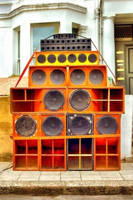 Stort orange sound system med mange højttalere foran en bygning