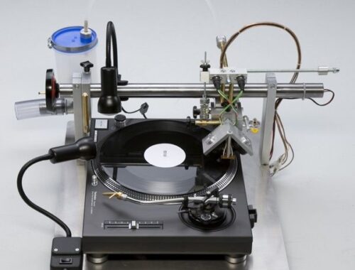 En vinylskæremaskine med plade, skærehoved og tekniske slanger