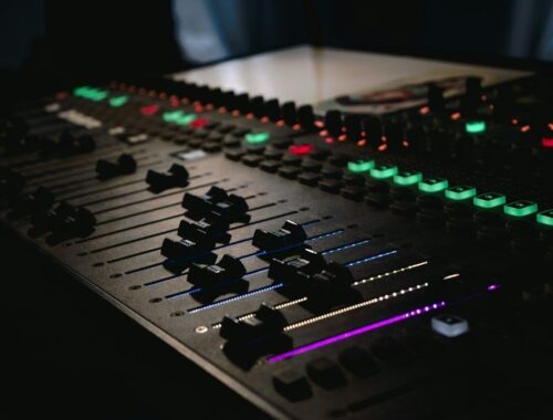 Lydteknikerens mixerbord med lysende knapper og skydefadere