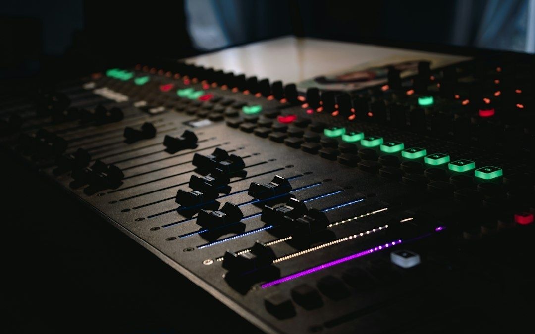 Lydteknikerens mixerbord med lysende knapper og skydefadere